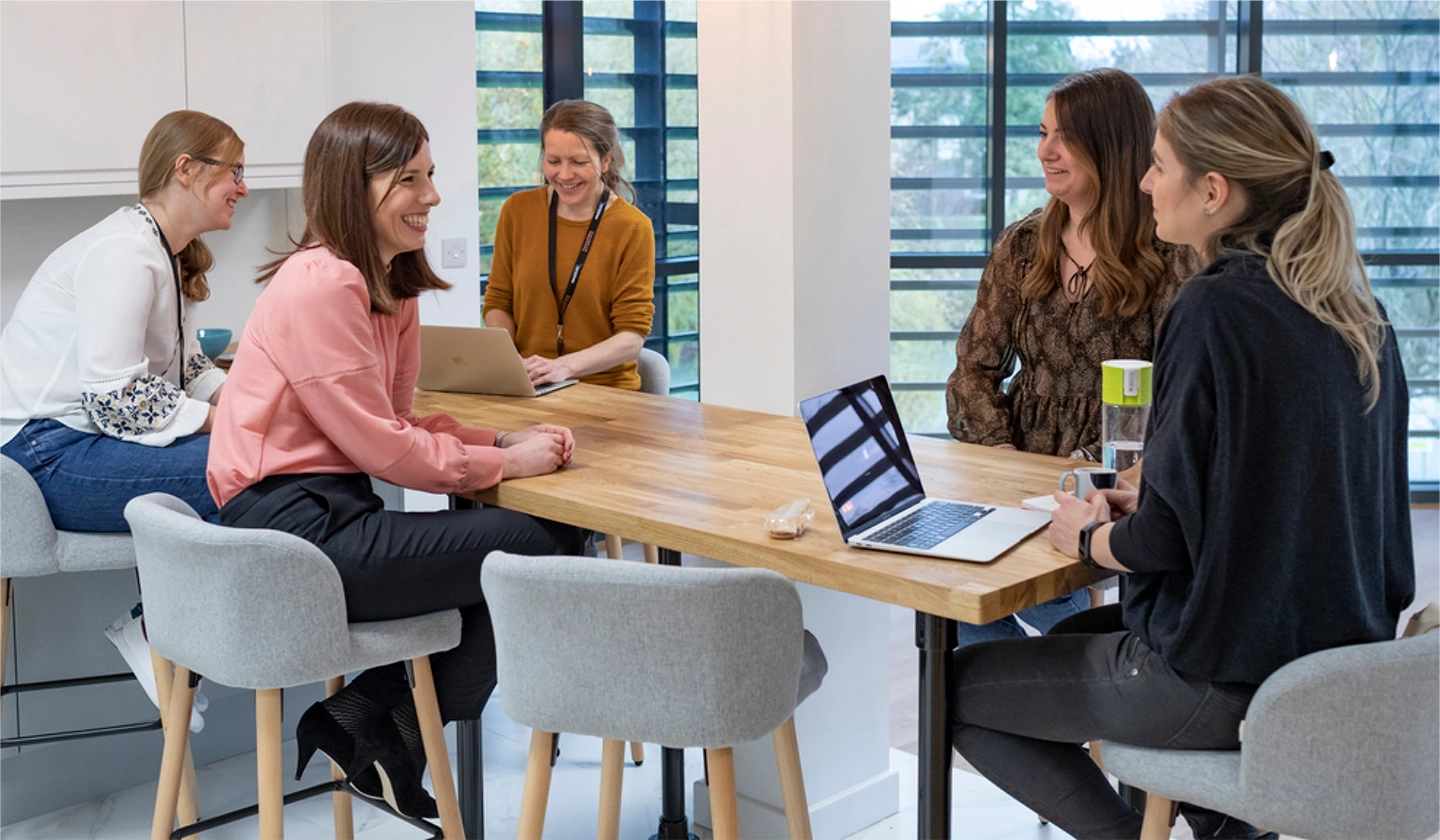 A candid shot of smiling Biofidelity team members in a common area.