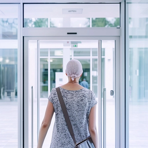 A cancer patient exits a healthcare facility. 